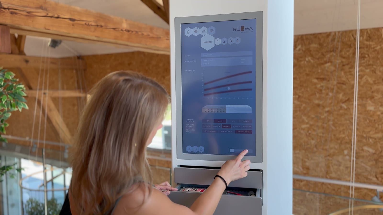 Schlafberaterin bedient das digitale Messsystem von Röwa im Showroom